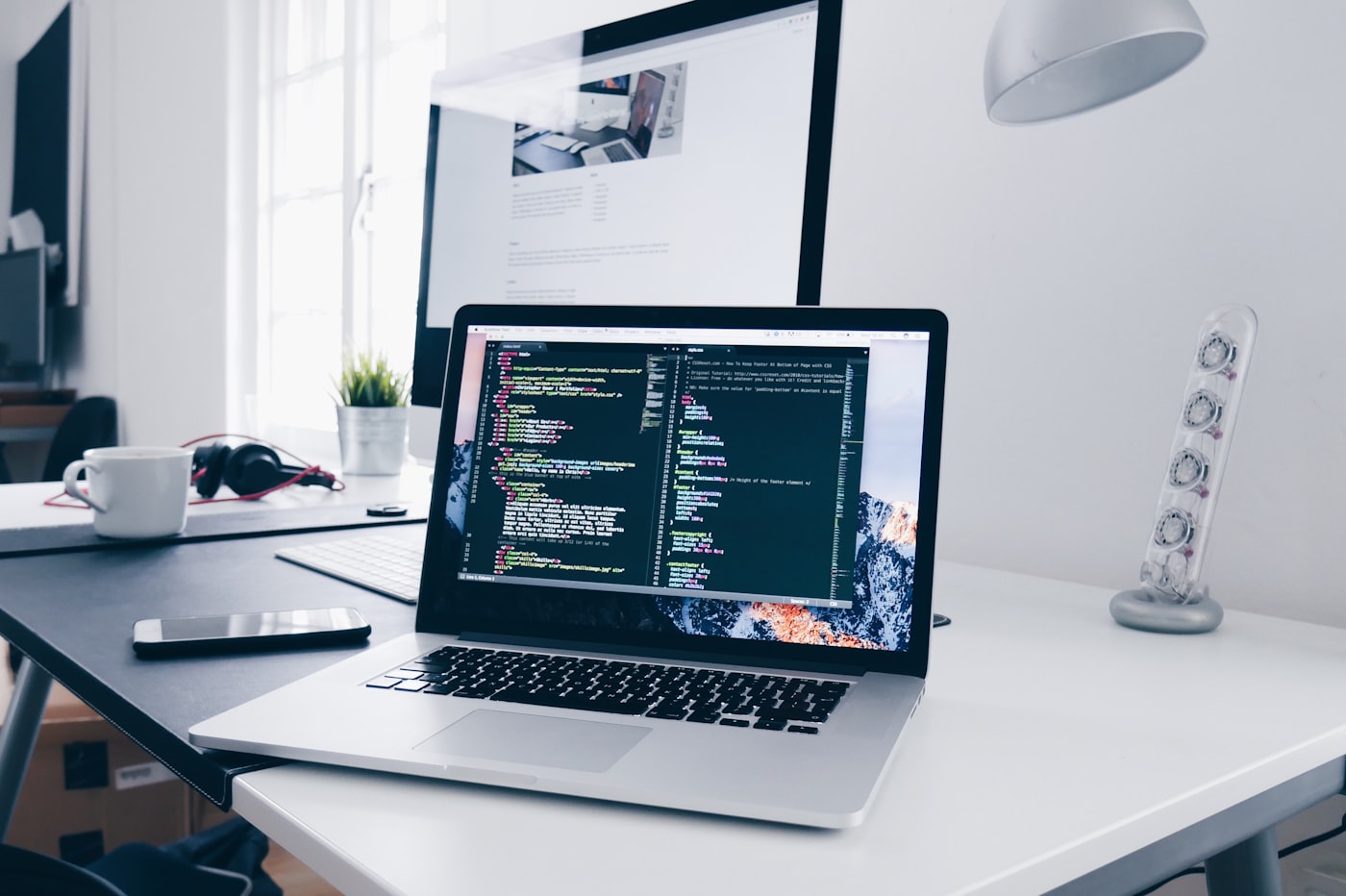 Developer workspace with laptop showing code on screen